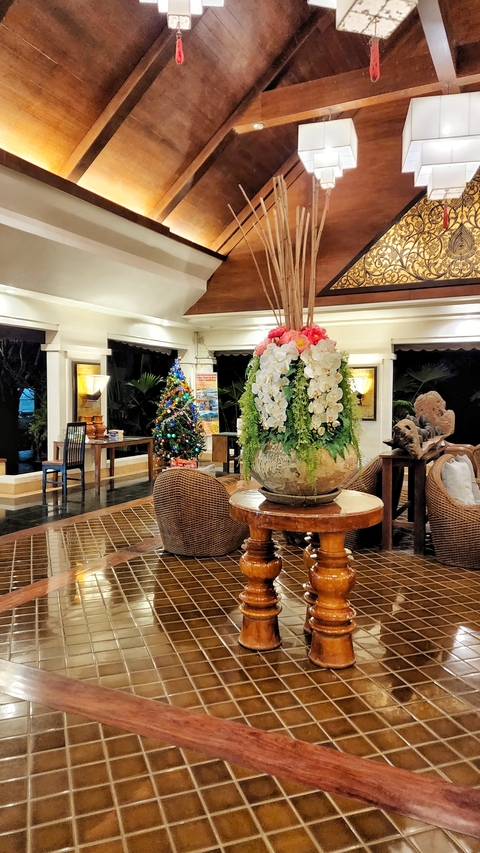       Hotel lobby with festive decorations and floral arrangements.
  