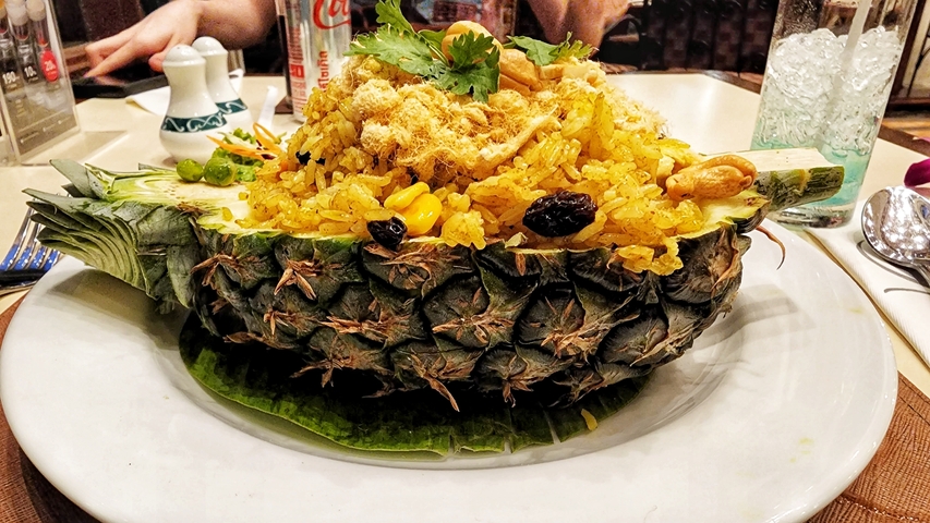       Pineapple fried rice served in a halved pineapple.
  
