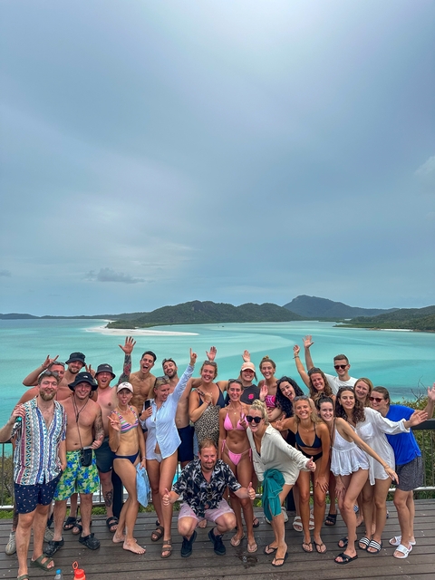 Group of people posing in front of a scenic beach view.
