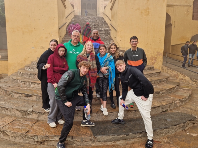       A group of people standing in front of a stepped structure.
  