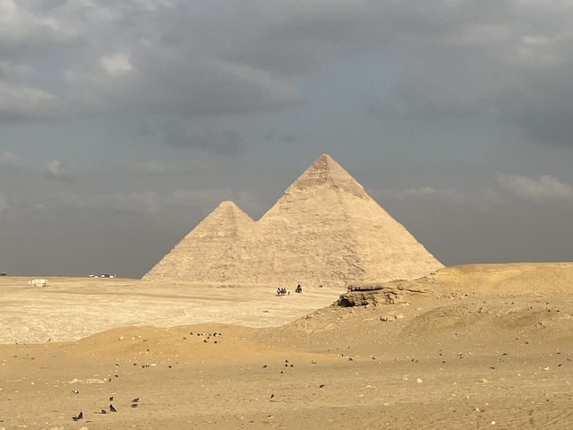       Desert landscape featuring two pyramids with a clear sky.
  