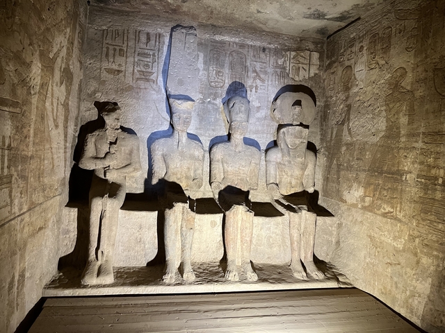       Interior of a tomb with four seated stone statues.
  