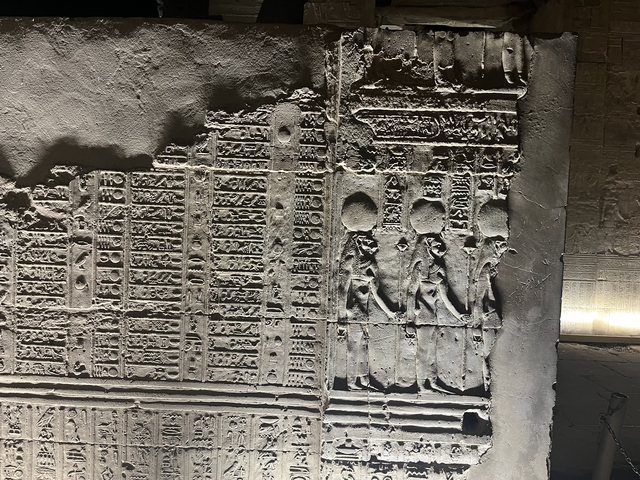       Detailed view of a wall with hieroglyphs and ancient carvings.
  