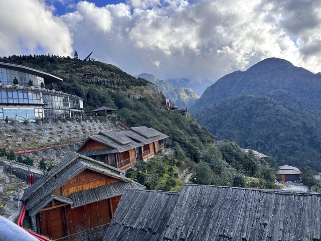       Scenic mountain view with buildings and lush greenery.
  