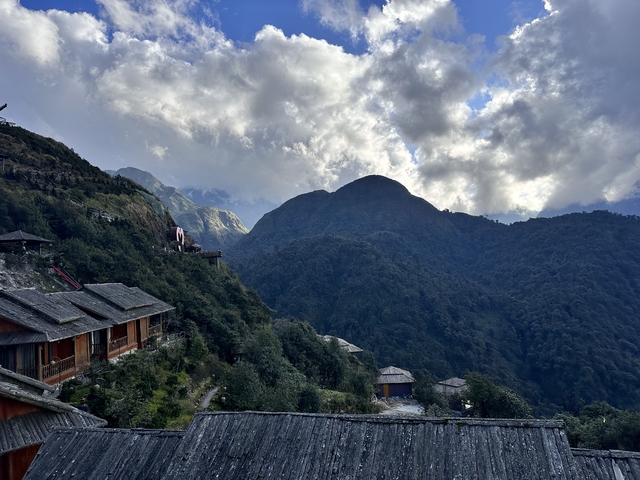       Mountain landscape with lodges and lush green hills.
  