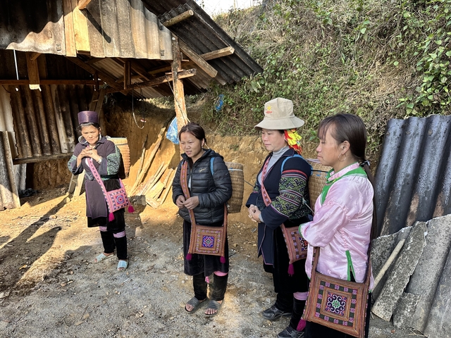       Four women in traditional clothing standing outdoors.
  