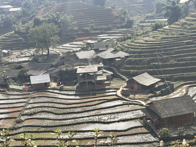       Aerial view of a settlement surrounded by terraced fields.
  