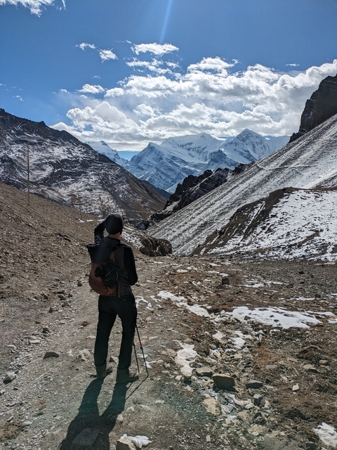 A person hiking in a mountainous snow-covered landscape.
