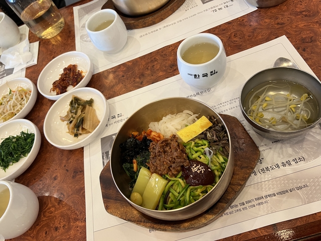       Traditional Korean meal served in bowls on a table.
  