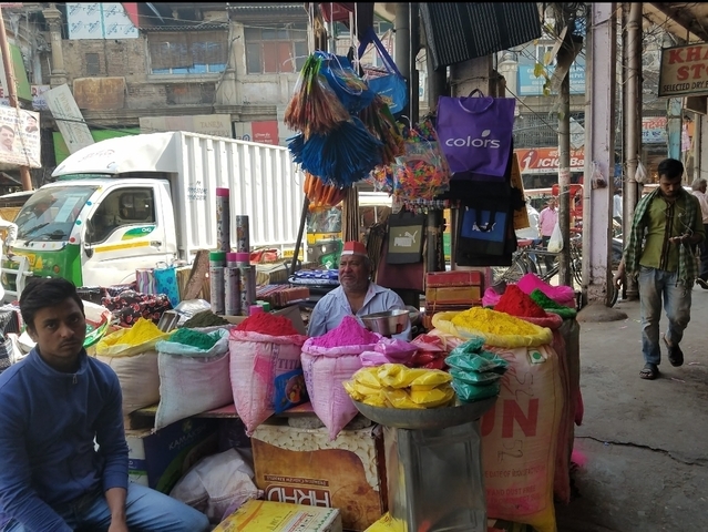 Colorful market stall selling vibrant powders.