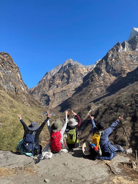Hikers posing with mountains in the background.