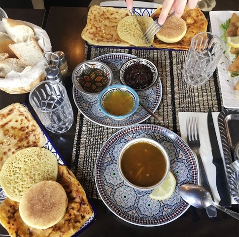 Traditional Moroccan meal with soup bowls and bread.
