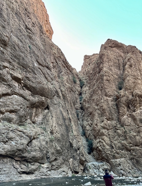       A narrow rocky gorge with towering cliffs.
  