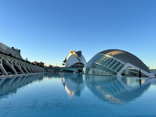 Modern and futuristic architecture bordering a large pool.