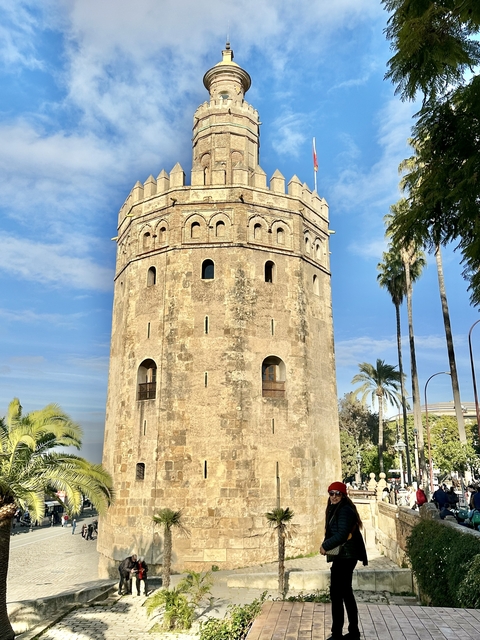 Historic tower surrounded by palm trees.
