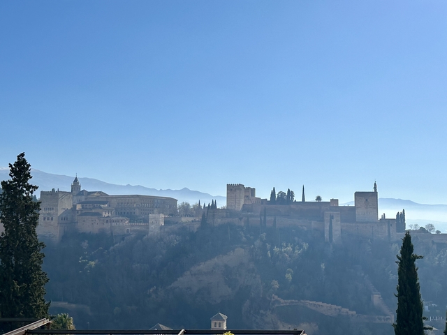       Silhouetted fortress with a mountainous backdrop.
  