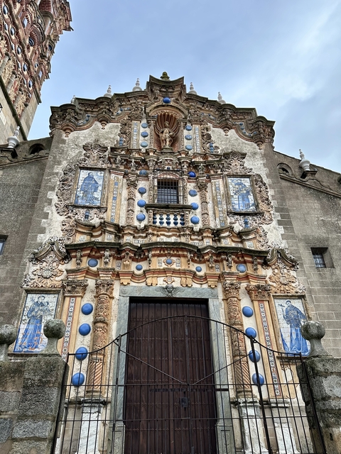       An ornate church facade with colorful decorations and detailed architecture.
  