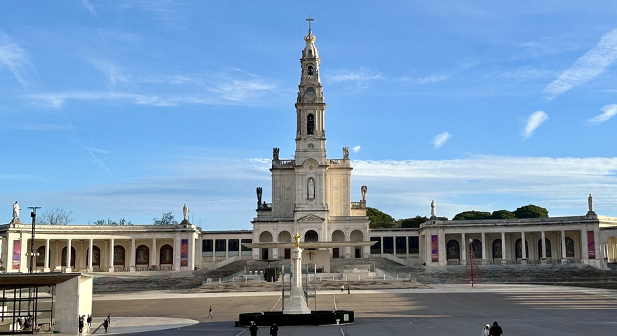 Large religious structure with a towering facade and statues.