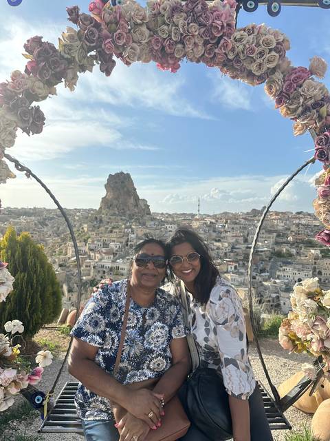 Upside-down image of two people posing with flowers and a cityscape.