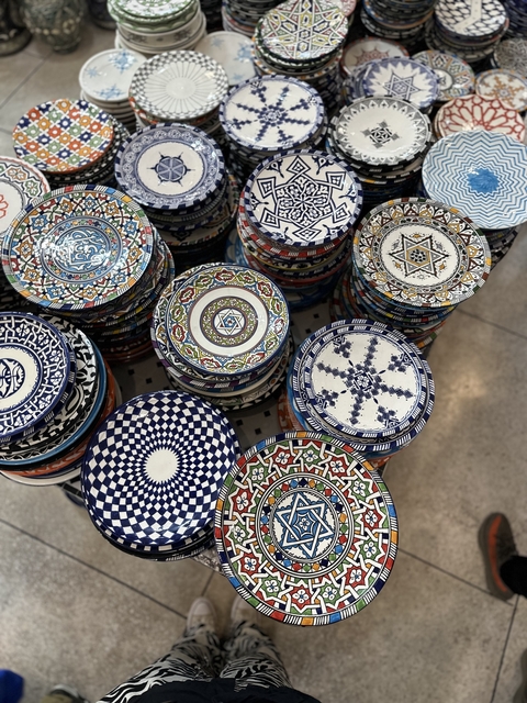       Stacks of colorful decorative plates with intricate patterns.
  