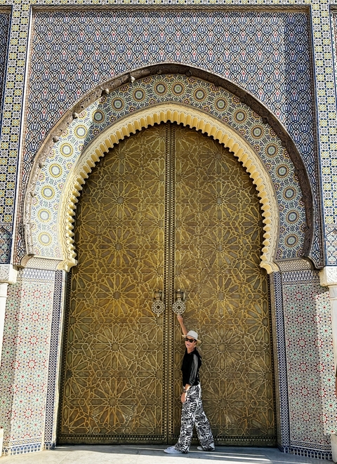       A gold ornate door with detailed tile work and an arched shape.
  