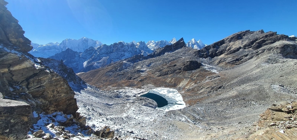       A frozen lake surrounded by snow-covered mountains.
  
