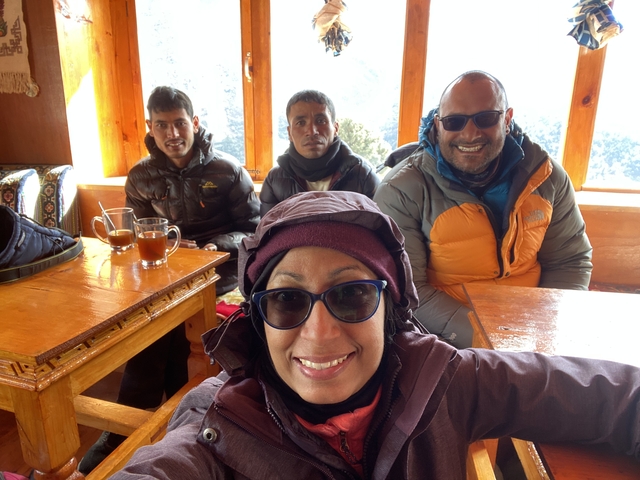       A group of four people in warm attire inside a lodge.
  