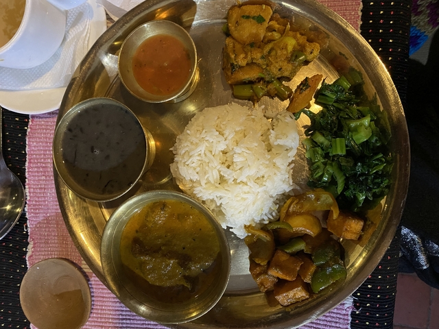       A traditional Nepali meal served on a metal platter with various dishes.
  