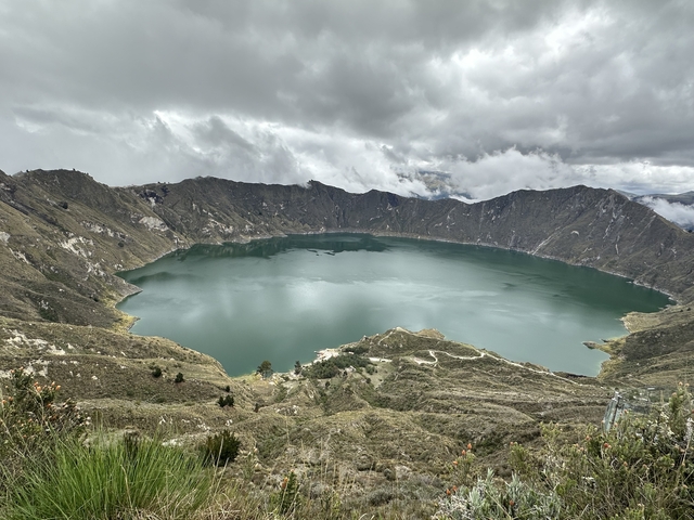       Picturesque view of a crater lake surrounded by hills.
  