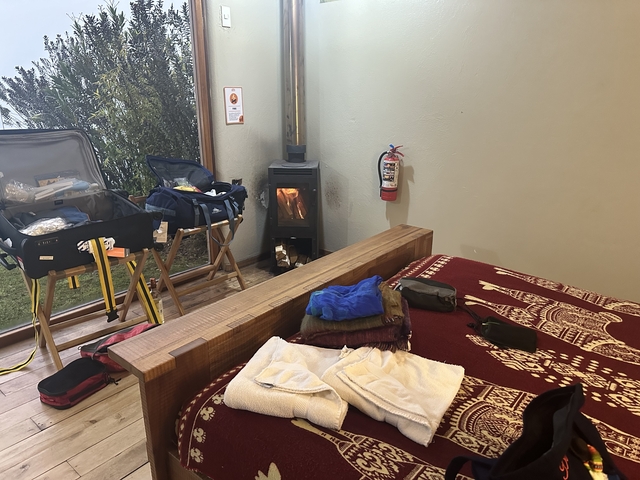       Interior of a room with luggage and a small stove.
  