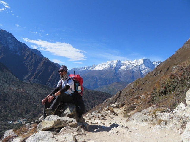       Hiker with snowcapped mountains in the background.
  