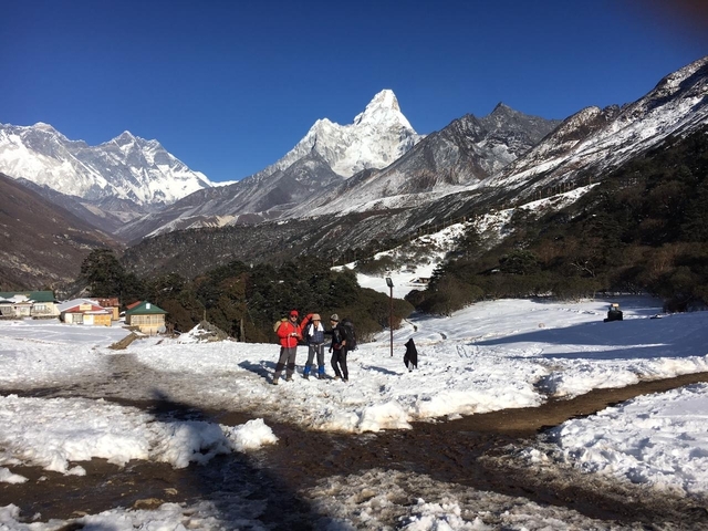 Hikers in snowy landscape with majestic mountains in the background.