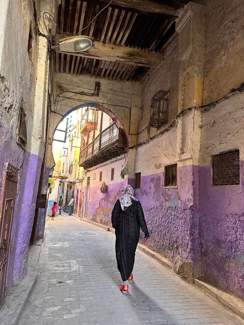 Person walking through a colorful Moroccan street.