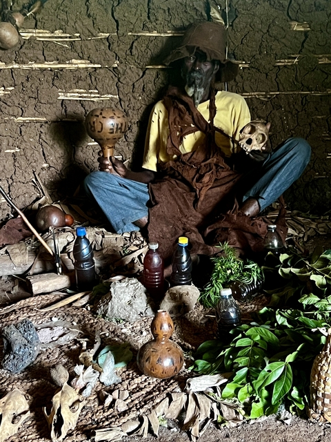       Person sitting with traditional tools and ingredients.
  