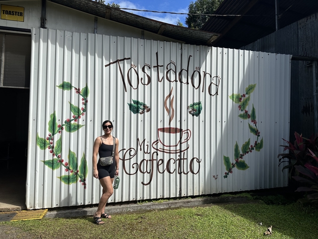 Woman posing in front of a café sign.