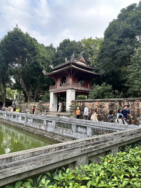 People walking near an ancient gate in a temple complex.