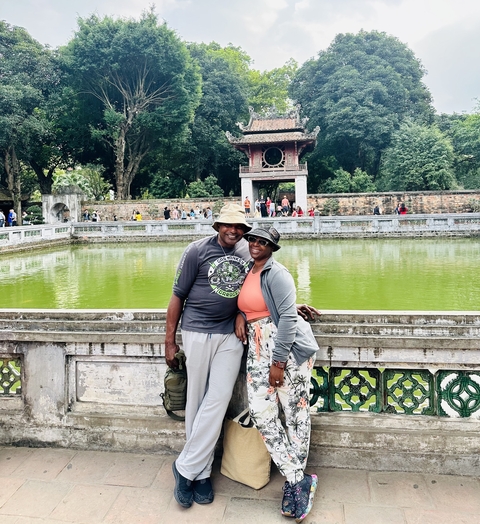 Couple posing in front of a pond within an ancient temple complex.