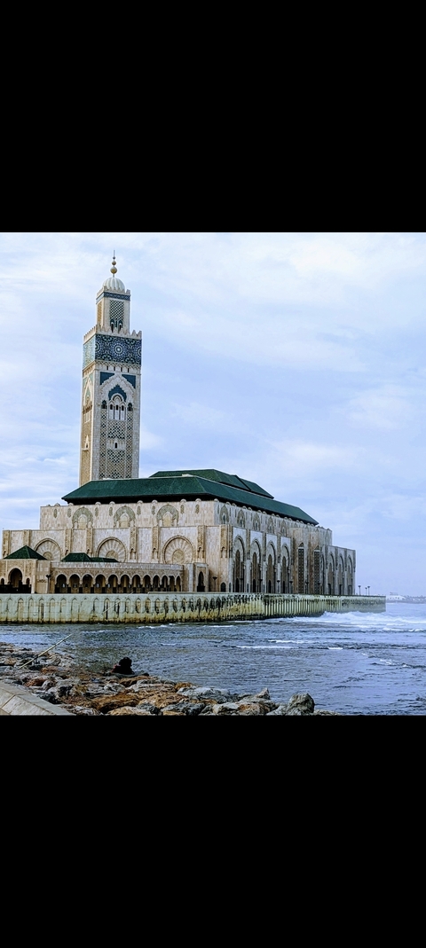 Grand mosque with a minaret against a blue sky.
