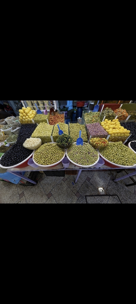 Variety of colorful olives and pickles on display in a market.