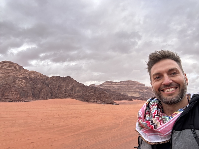 Person posing in desert landscape with rocky hills
