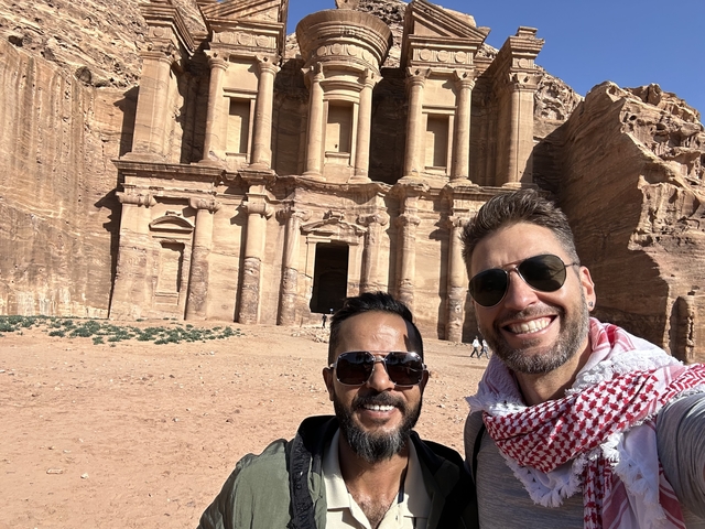       Two people in front of Petra’s rock-cut architecture
  