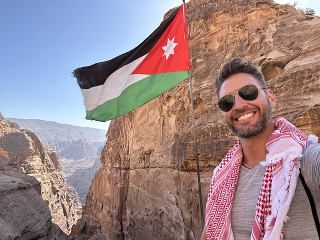       Person with Jordanian flag and rocky landscape
  