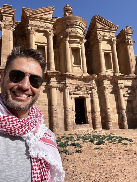       Person posing in front of the Petra rock-cut architecture
  