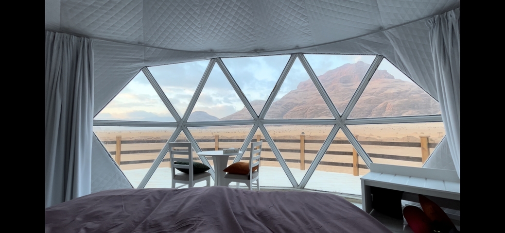       View from inside a dome accommodation with a mountain view.
  