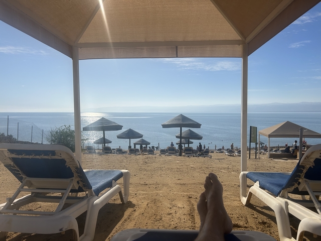       View of beach and sea from under an umbrella
  