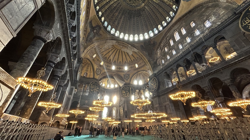       Interior view of a large historical mosque with chandeliers
  