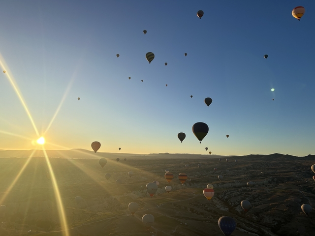 View of numerous hot air balloons flying during sunrise