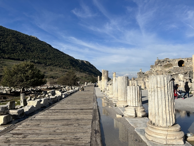       Ancient ruins with stone columns under a blue sky.
  