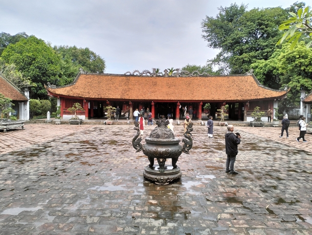       Courtyard of a traditional temple with visitors.
  