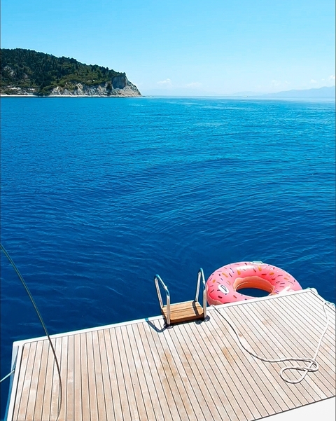 Turquoise sea with a floating pink swim ring.